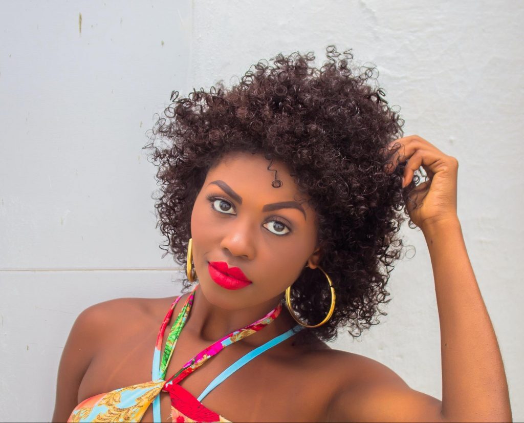 Mulher de cabelos curtos cachedos e pele negra
