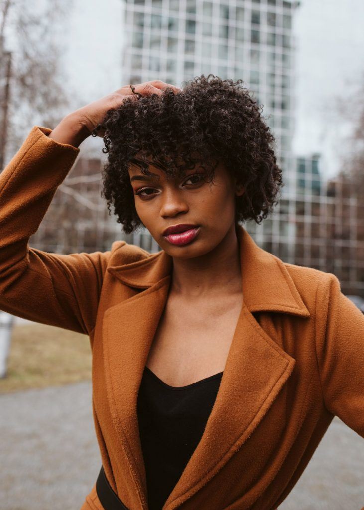 mulher com cabelo curto cacheado com franja