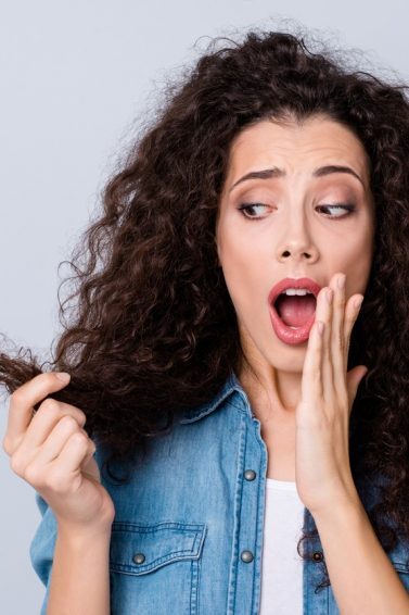 mulher olhando o cabelo preocupada
