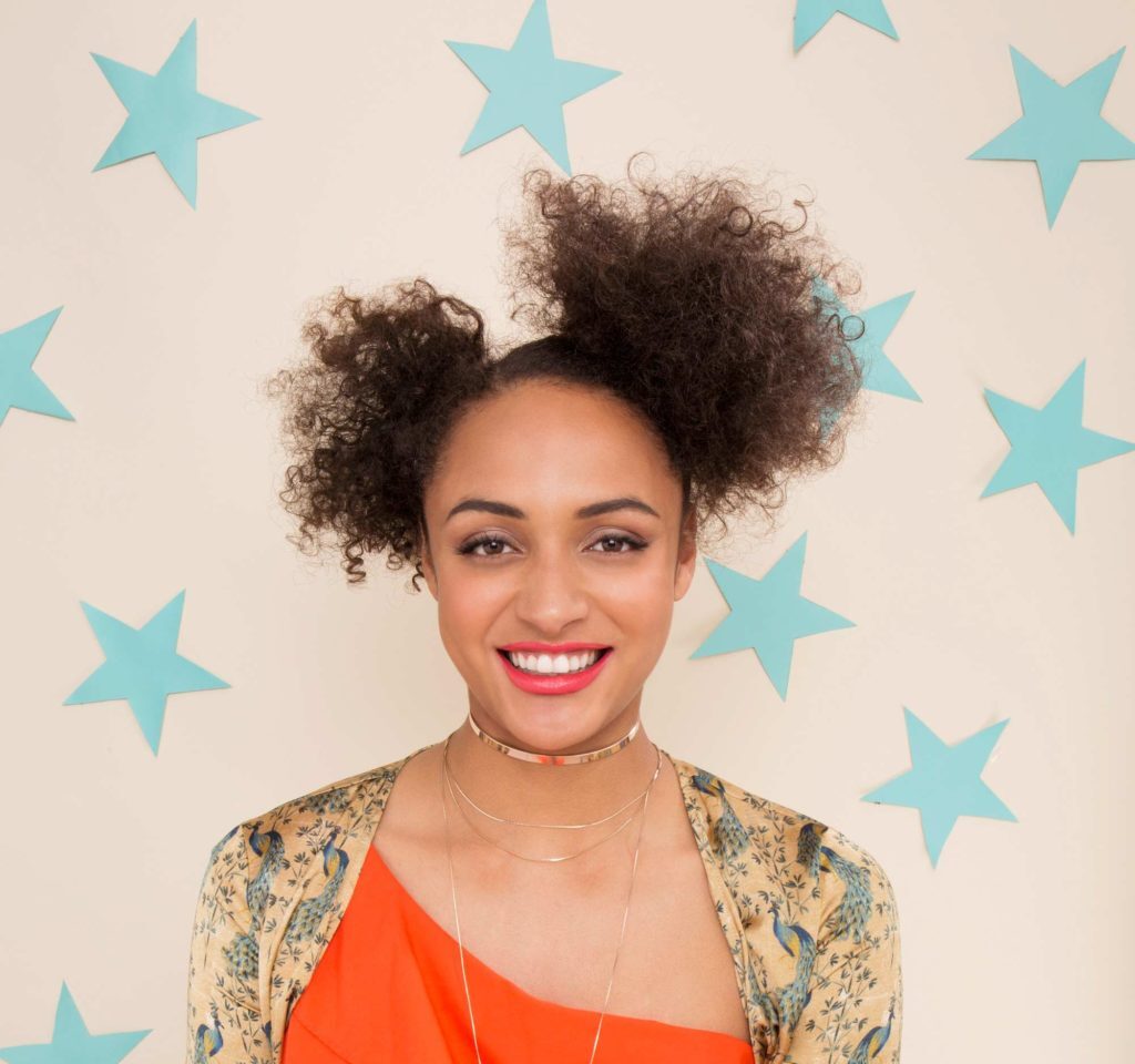 Mulher com cabelo afro e coque duplo