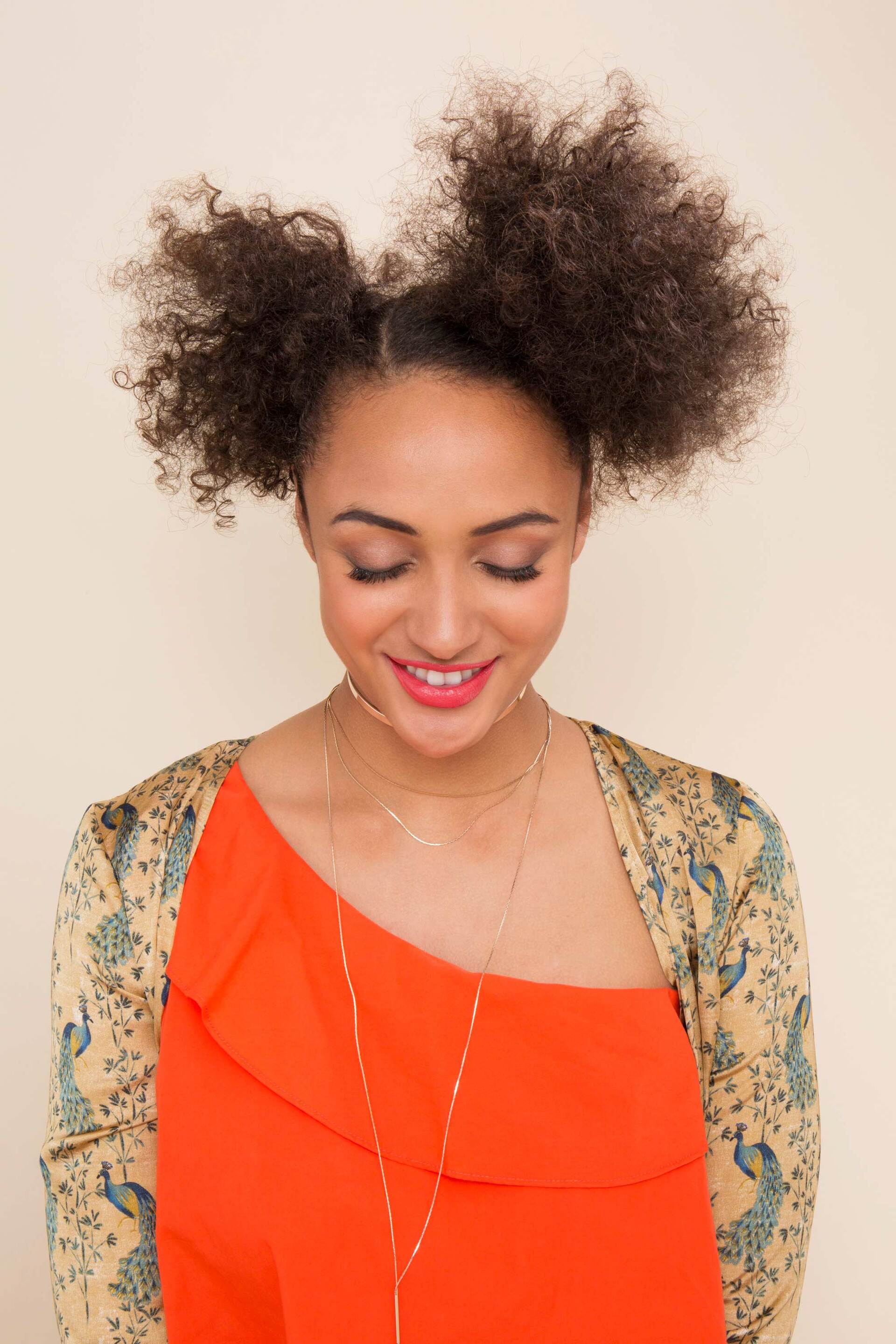 Mulher com cabelo afro e coque duplo