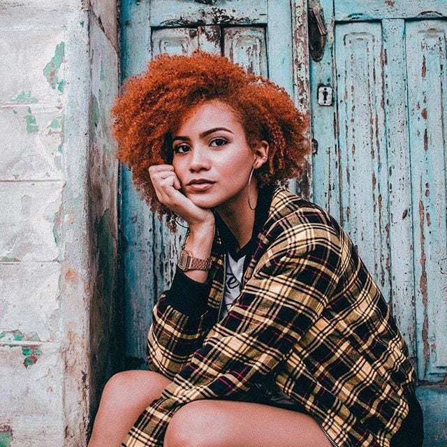 Influenciadora Julia Lira com jaqueta xadrez amarela e preta