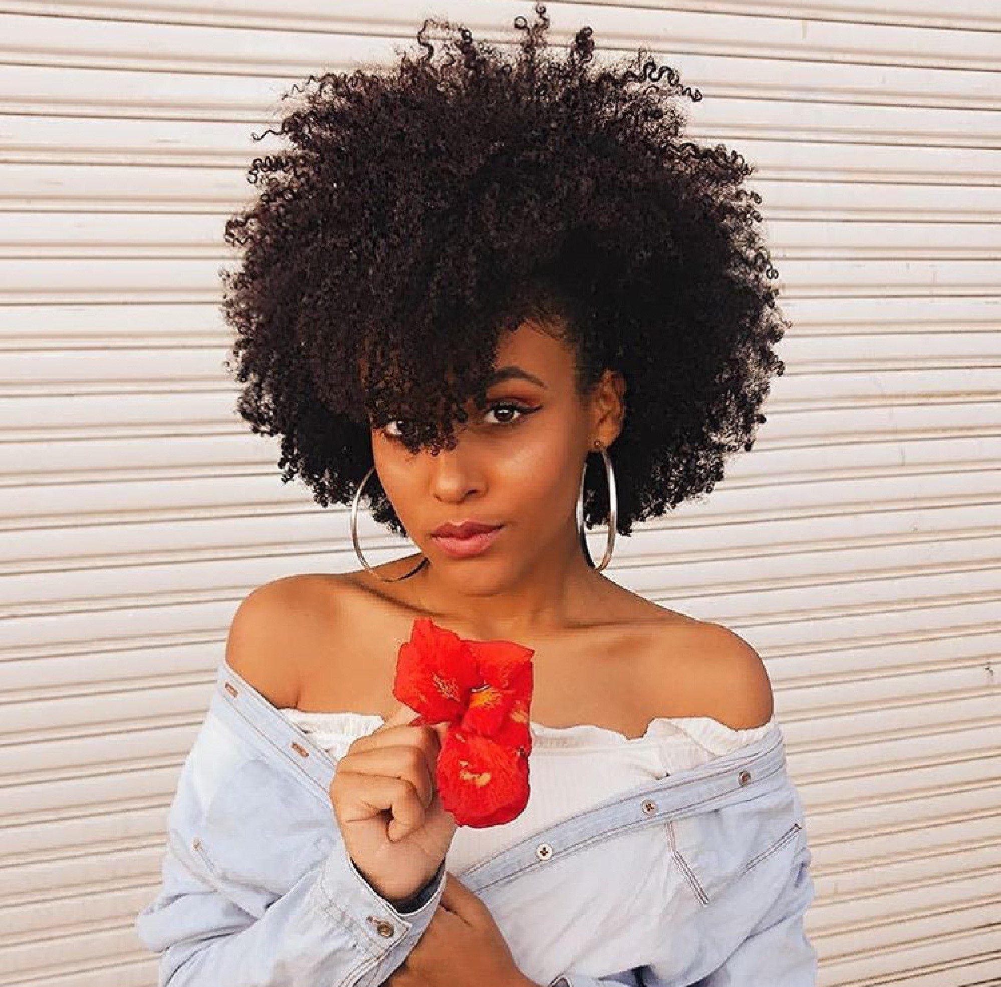 Mulher com franja falsa para cabelo crespo