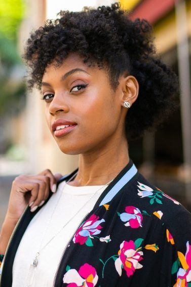 Modelo com cabelo castanho escuro crespo com penteado semipreso