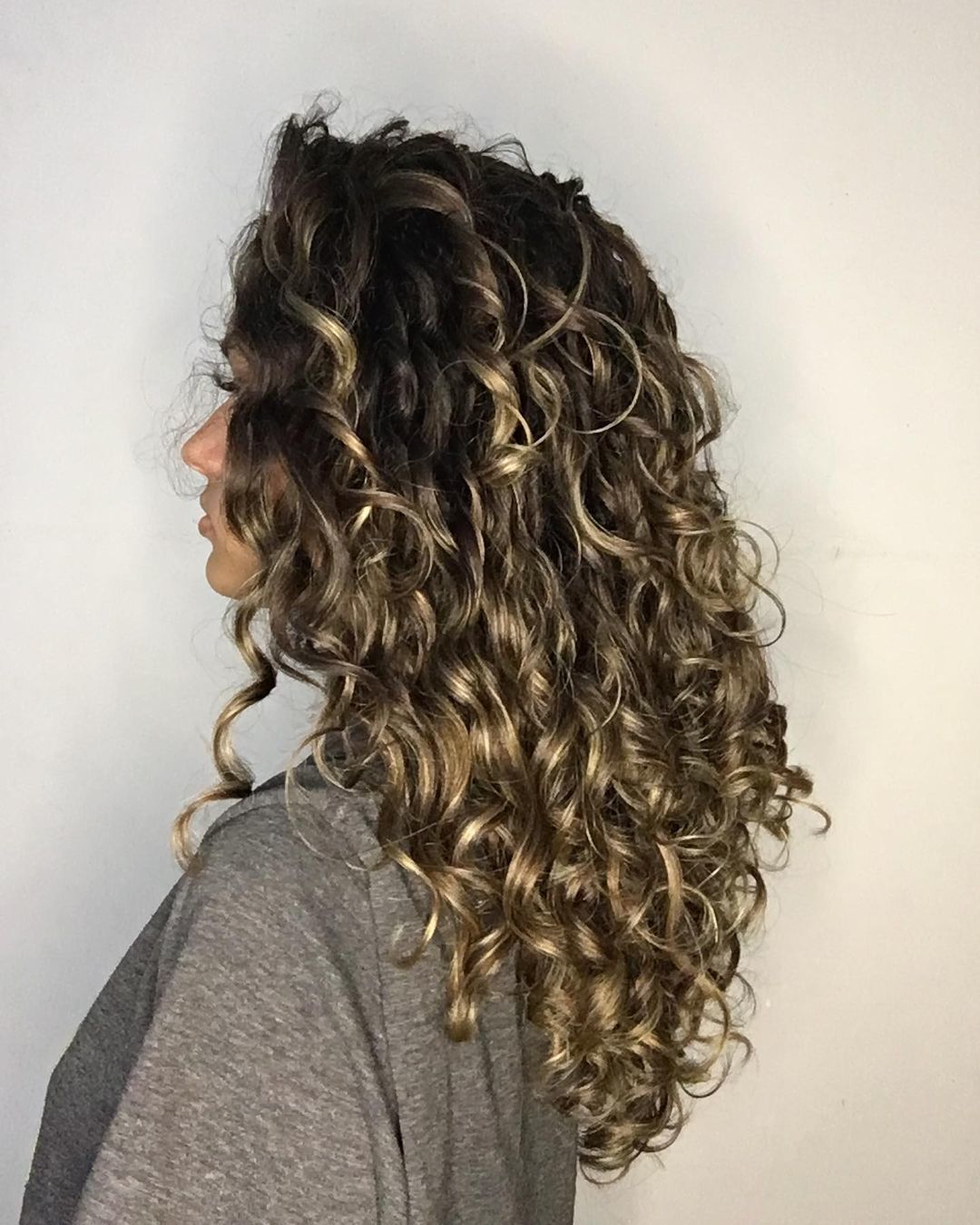 Cabelo cacheado morena iluminada com luzes