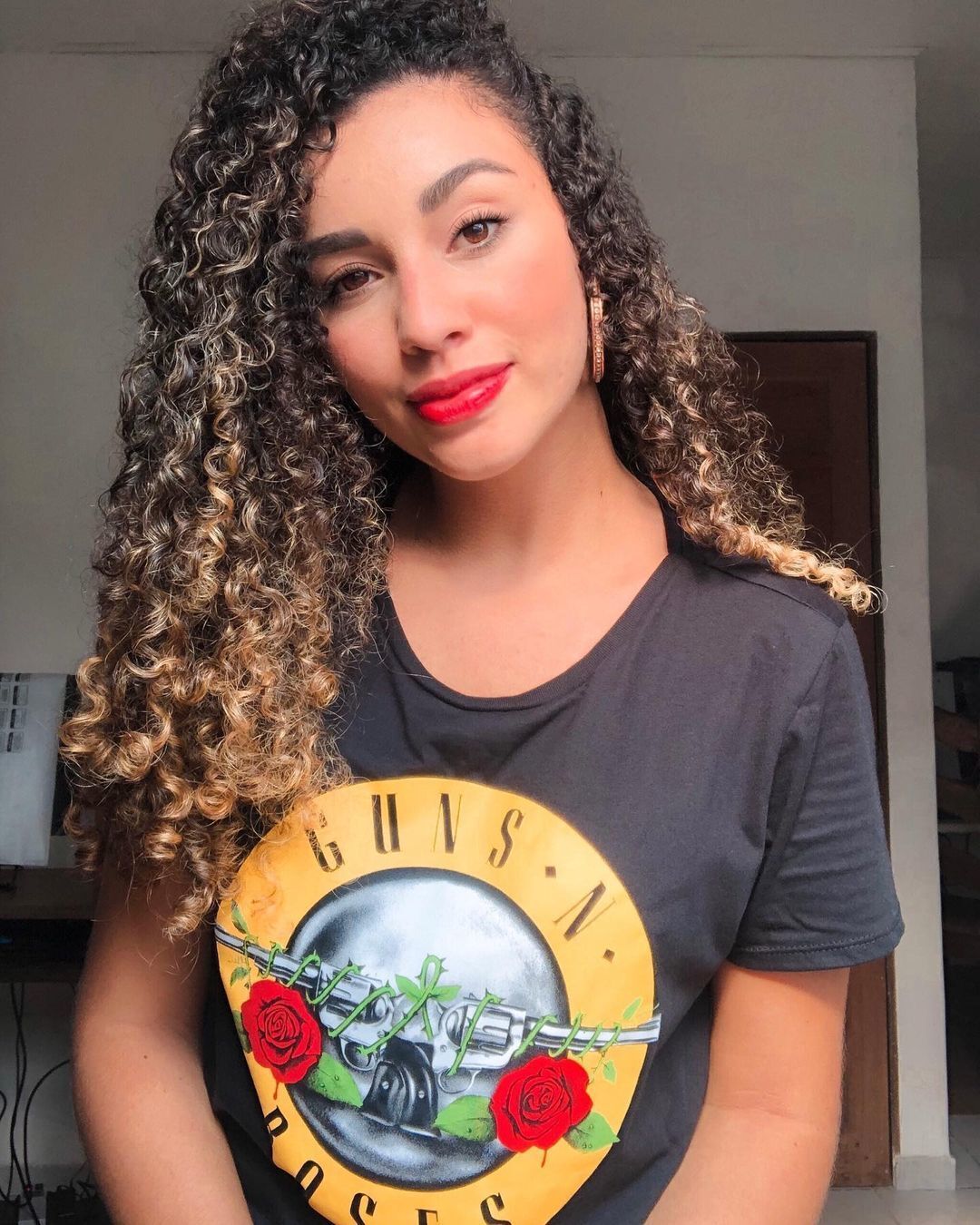 Mulher negra com cabelo cacheado morena iluminada