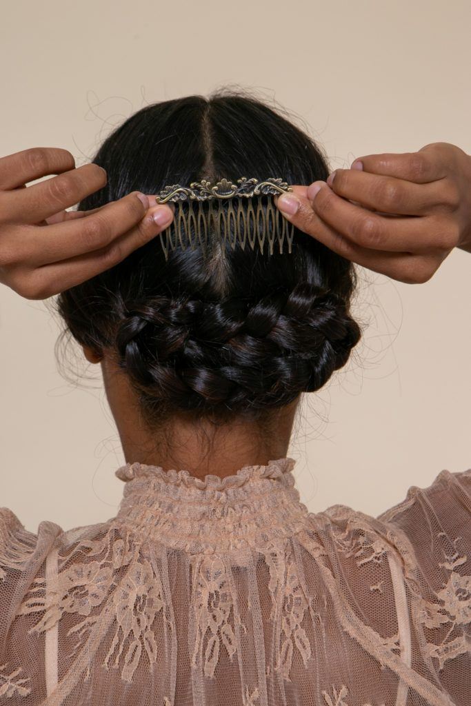 modelo com tranças cruzadas posicionando acessório no penteado de noiva