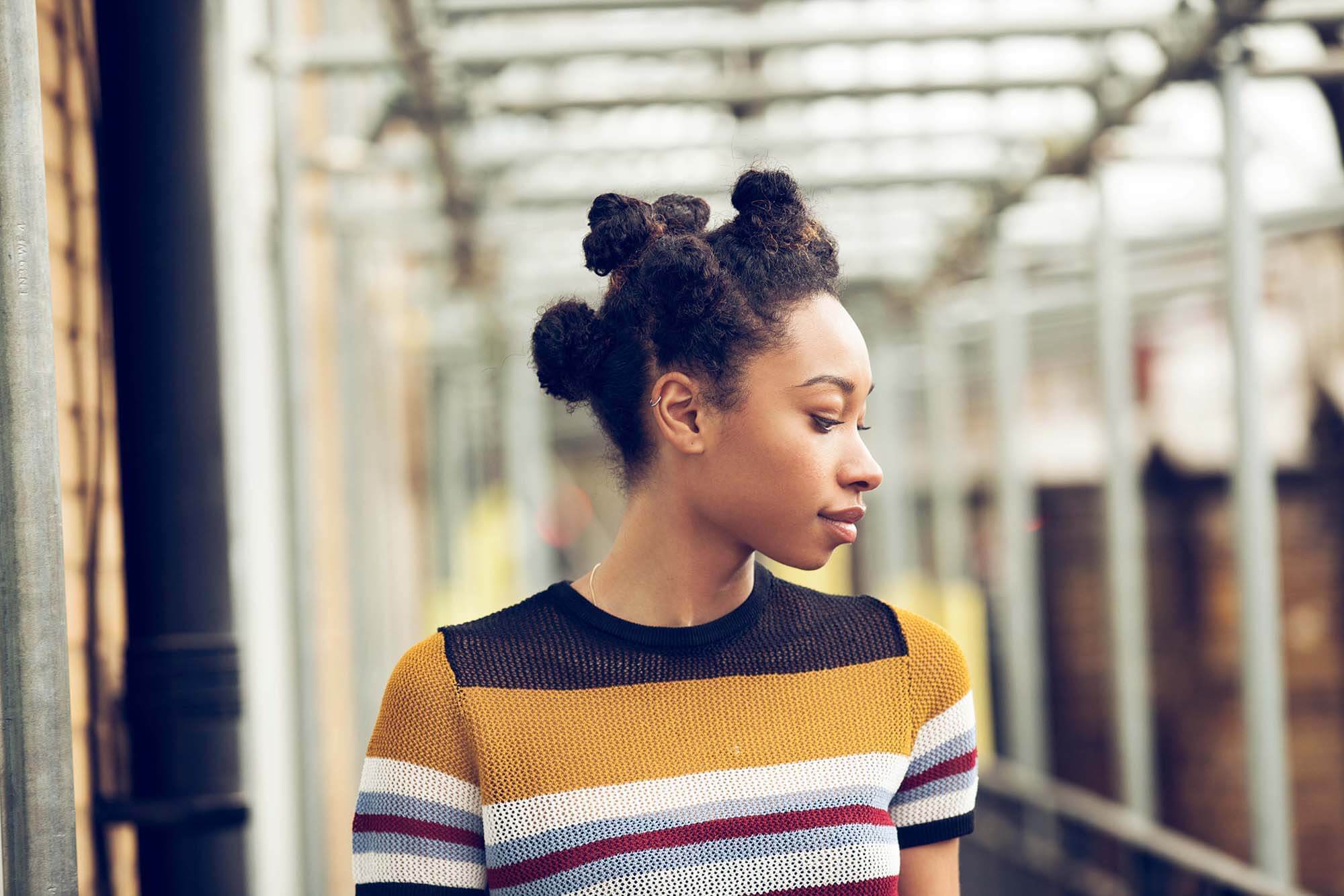 Mulher usa bantu knots como um dos penteados afro sugeridos