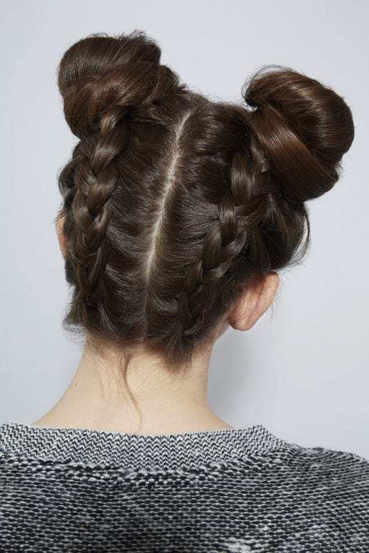 modelo de cabelo castanho com meio coque trançado.
