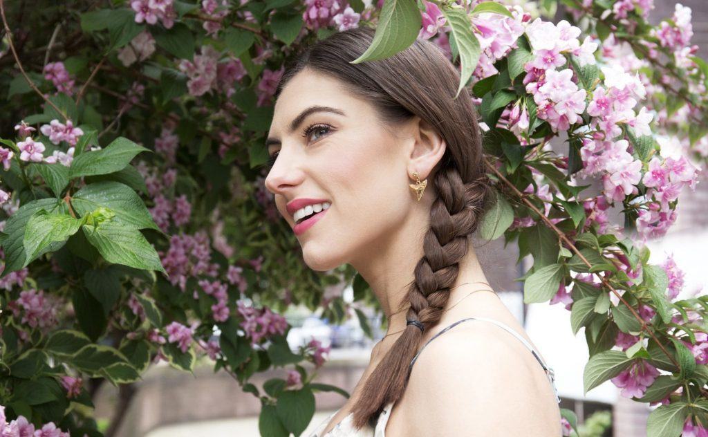 mulher com trança lateral e cabelo castanho
