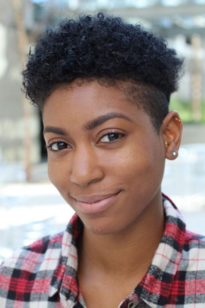 Mulher com cabelo crespo e corte tapered, de laterais raspadas