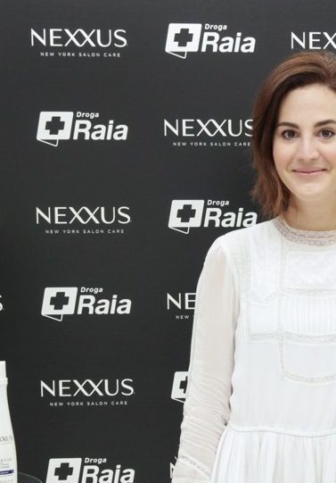 Vic Ceridono posa com a mão na cintura usando um vestido branco