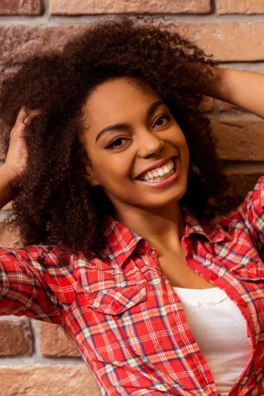 zica nos cabelos: modelo com cabelo crespo sorrindo