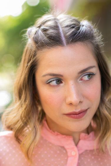 Modelo com cabelo semipreso loiro e camisa rosa