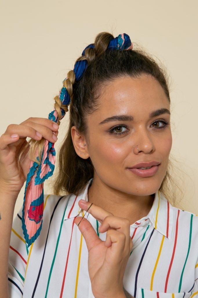 modelo de cabelo ondulado loiro com mechas loiras com um penteado semipreso trançado com lenço