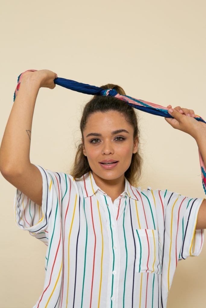 modelo de cabelo ondulado loiro com mechas loiras fazendo um semipreso trançado com lenço