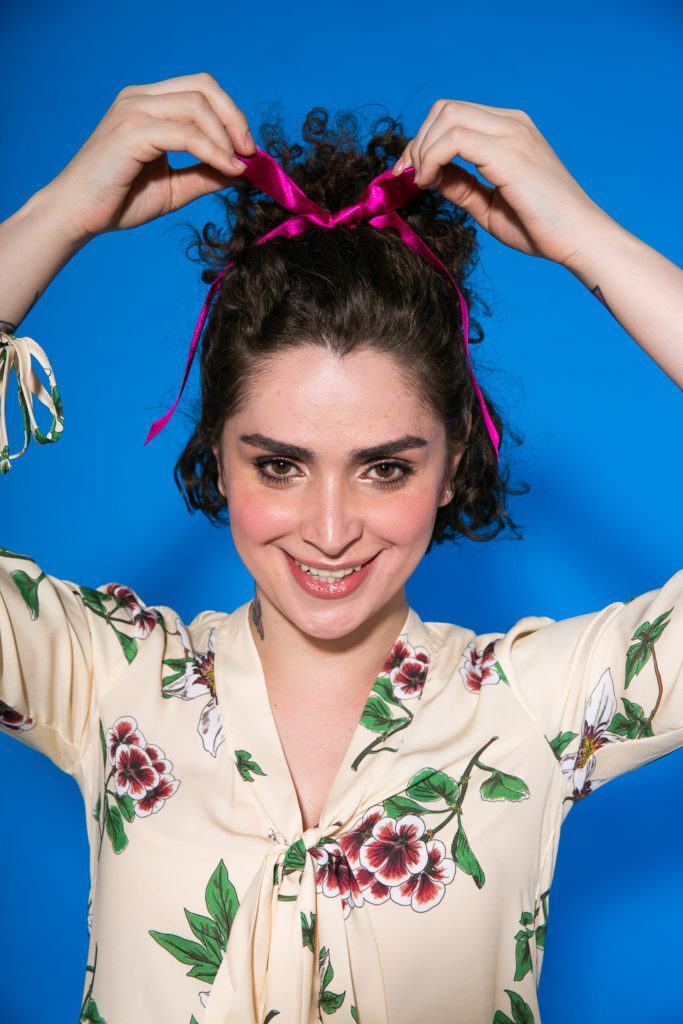 Cabelo cacheado curto sendo amarrado