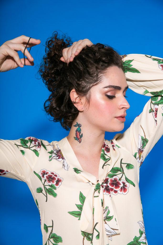 Cabelo cacheado curto sendo amarrado