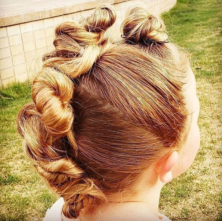 Menina com penteado de moicano com coques