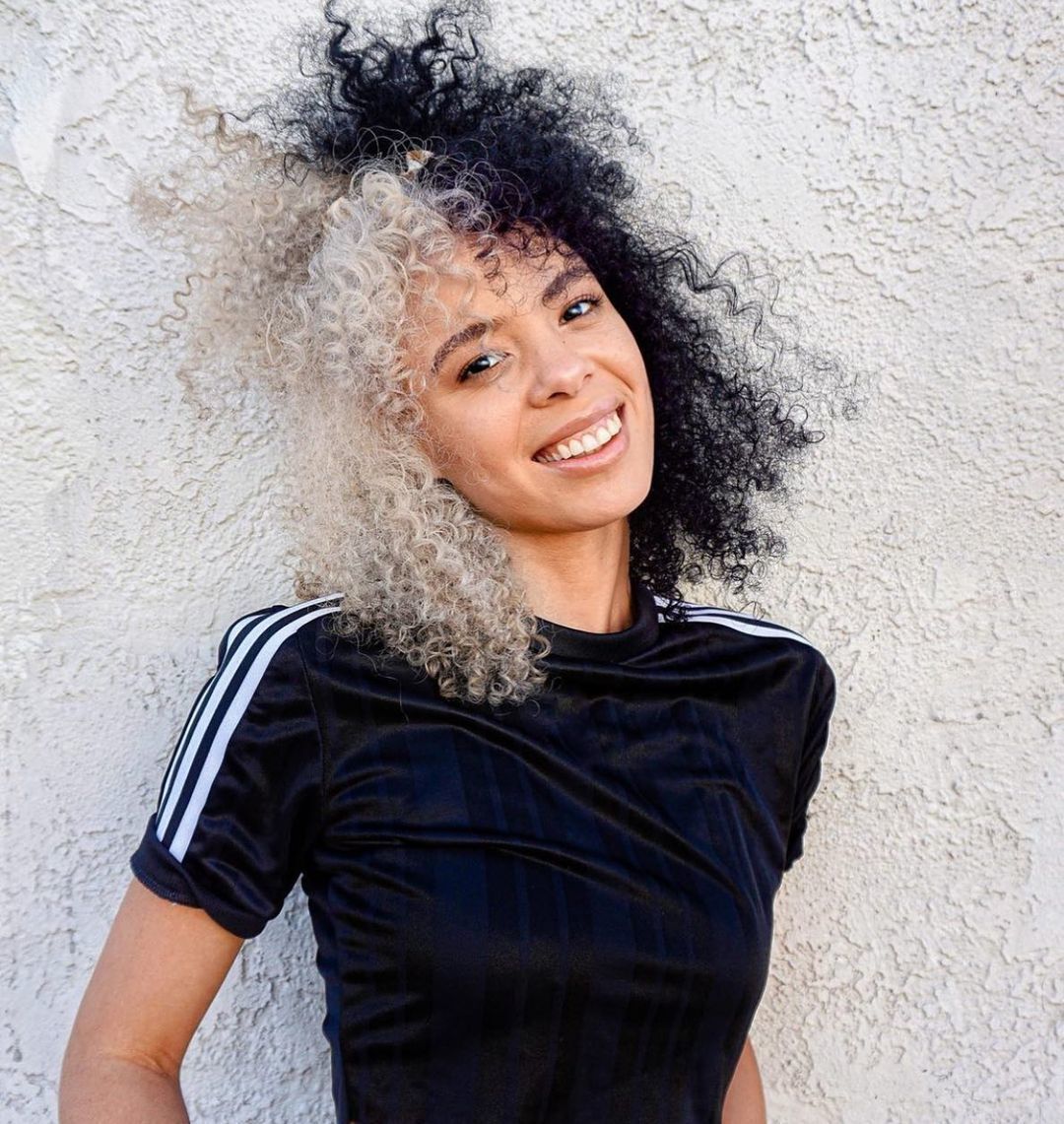 Mulher com cabelo cacheado de duas cores: branco e preto