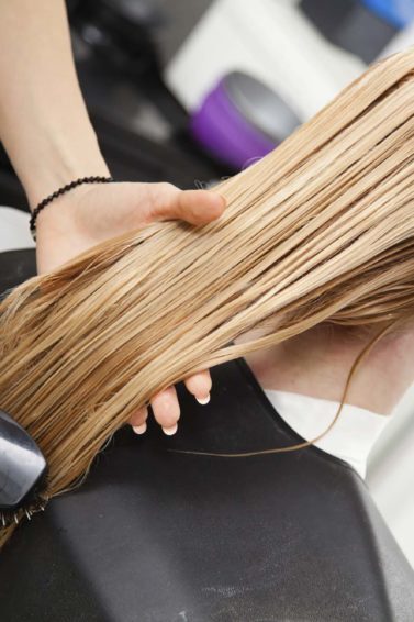Mulher loira se submete a tratamentos de cabelo no salão