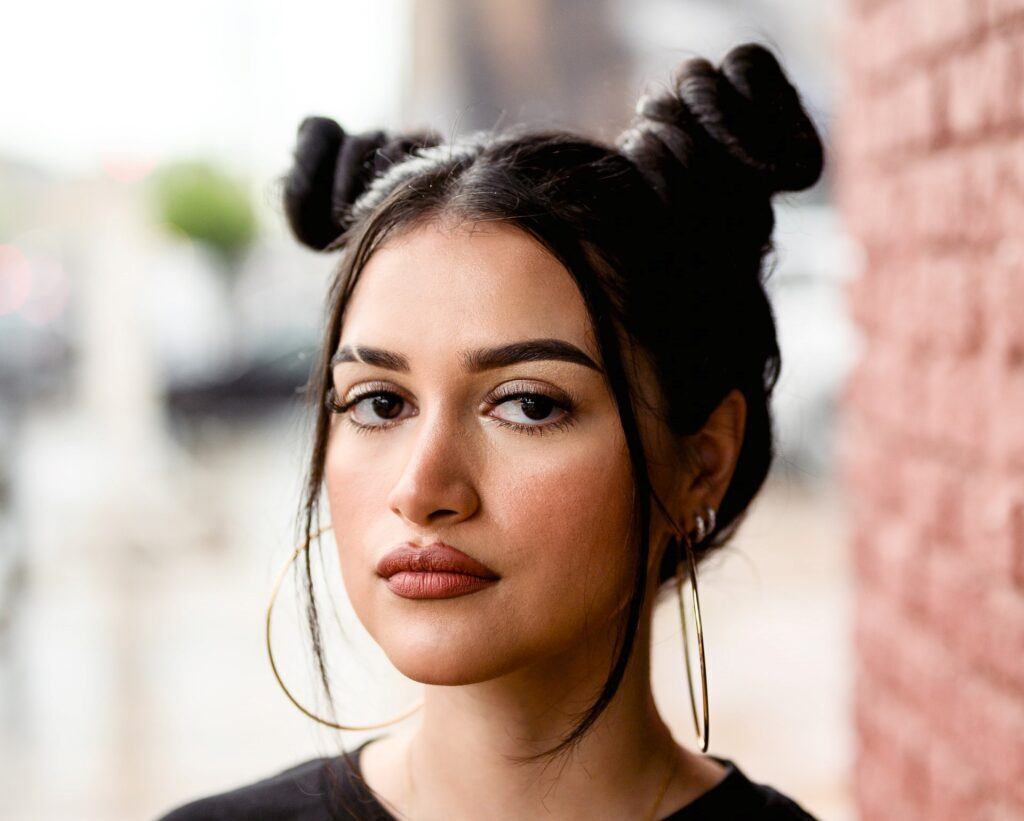 Mulher posa com space buns no cabelo estilo skatista