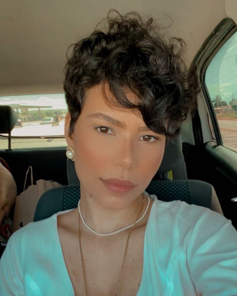 mulher de rosto formato triangulo com corte de cabelo pixie cacheado