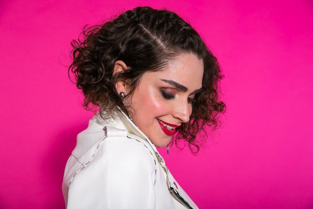 Mulher com cabelo castanho escuro, trança discreta na lateral e corte short bob