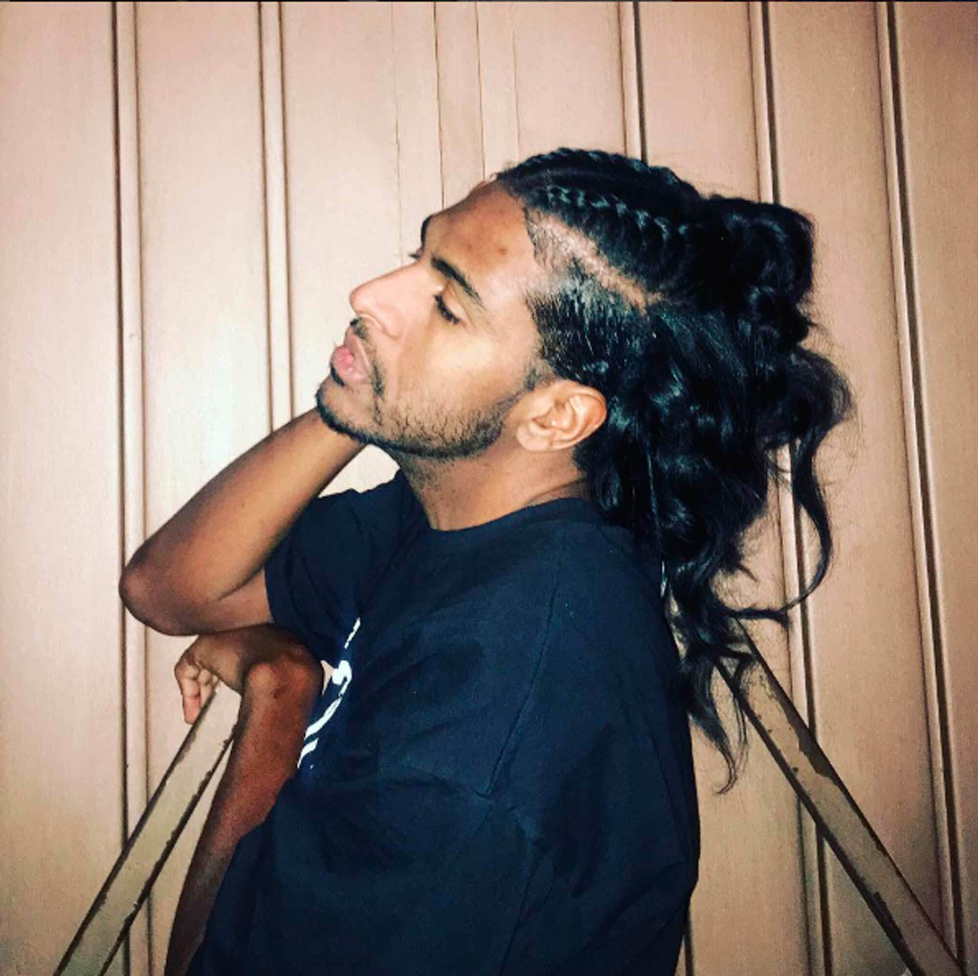 Rico Dalasam com cabelo cacheado preto