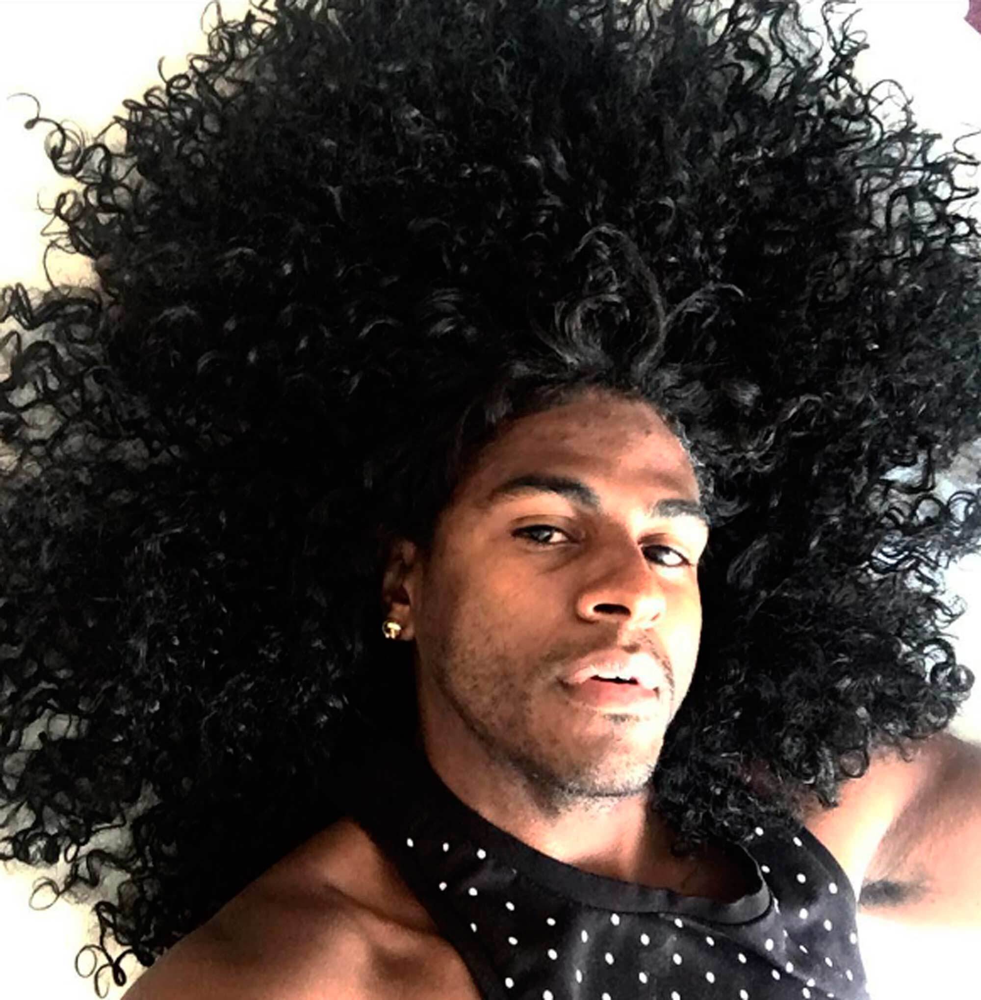 Rico Dalasam com cabelo cacheado preto