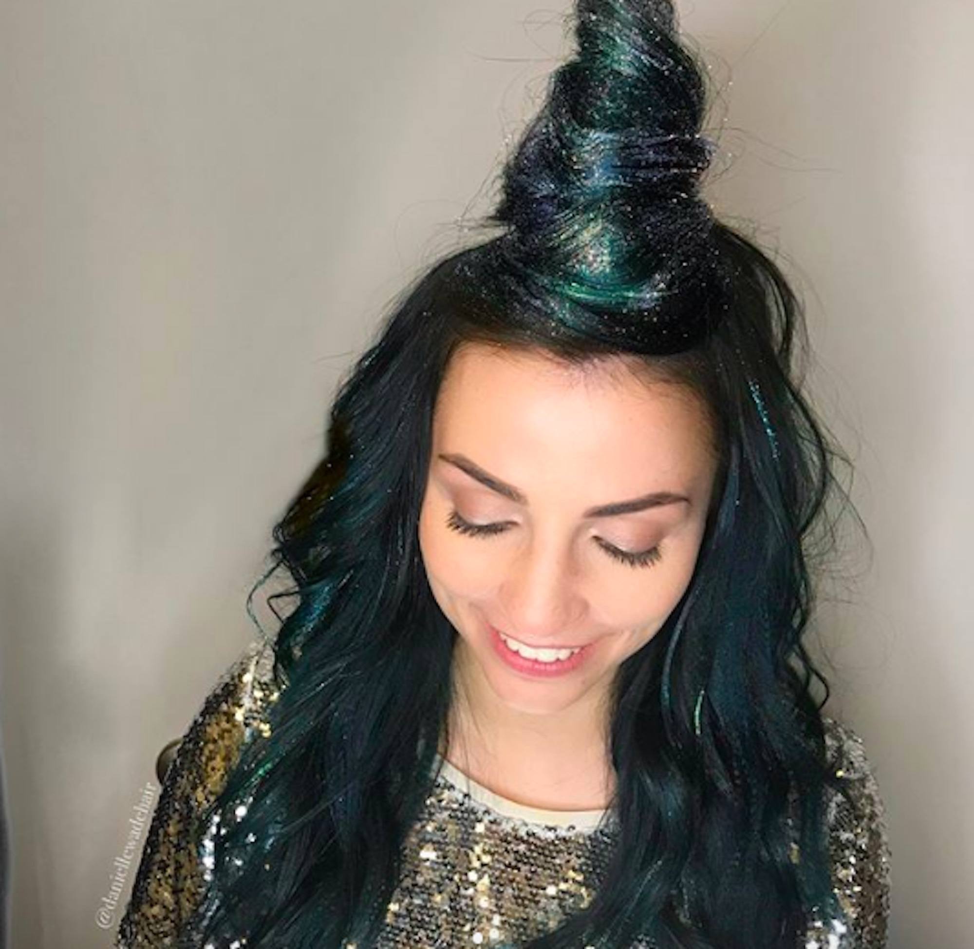 Mulher com cabelos verdes e coque com glitter verde