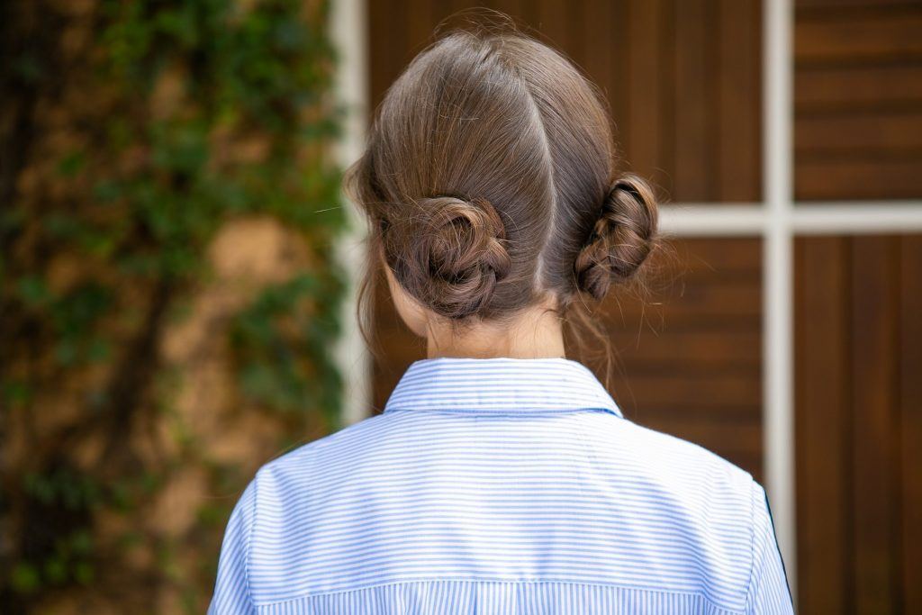 Mulher com penteado de coque duplo trançado
