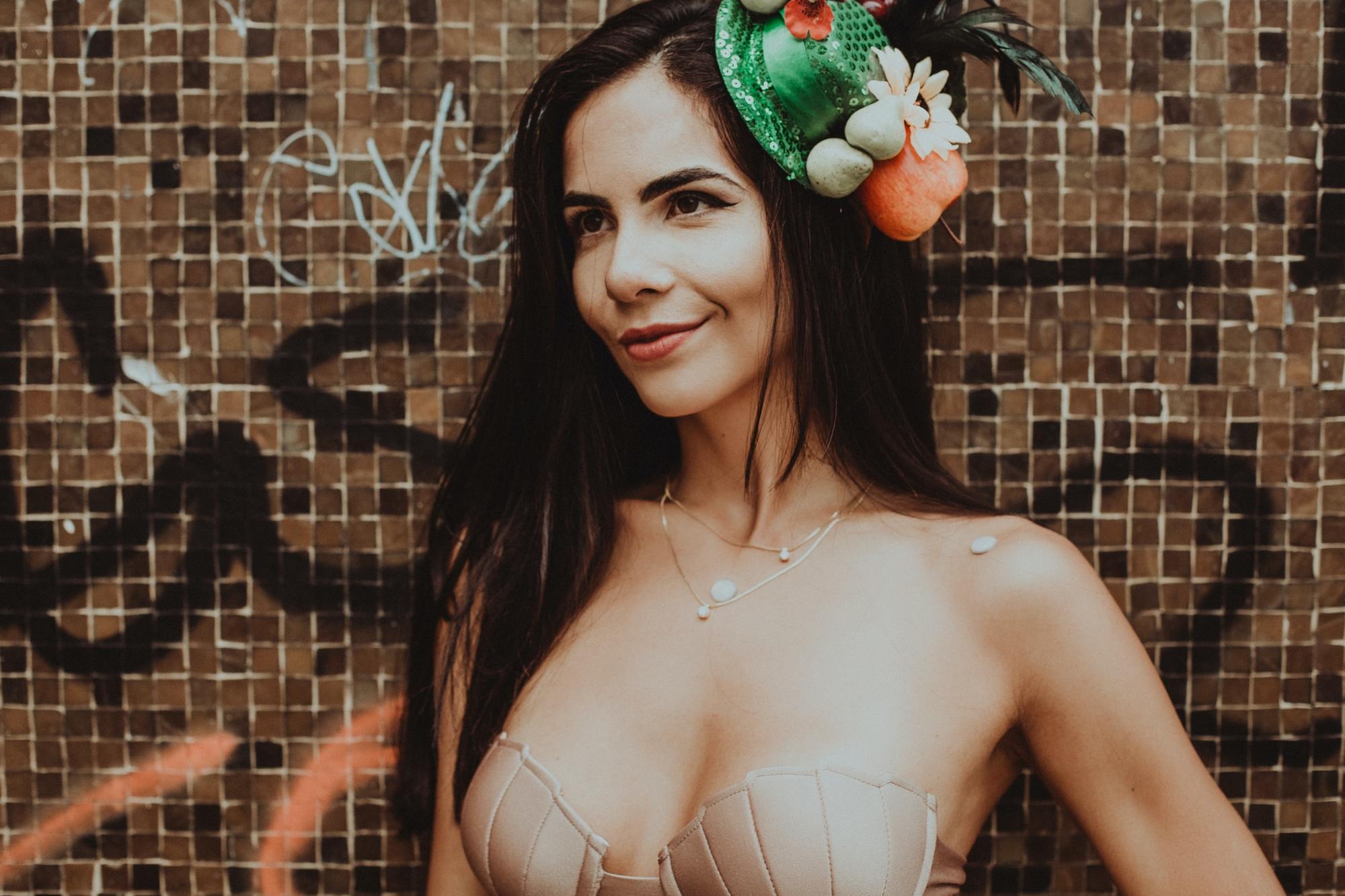 mulher com cabelo solto usa biquini e acessório tiara festiva de carnaval