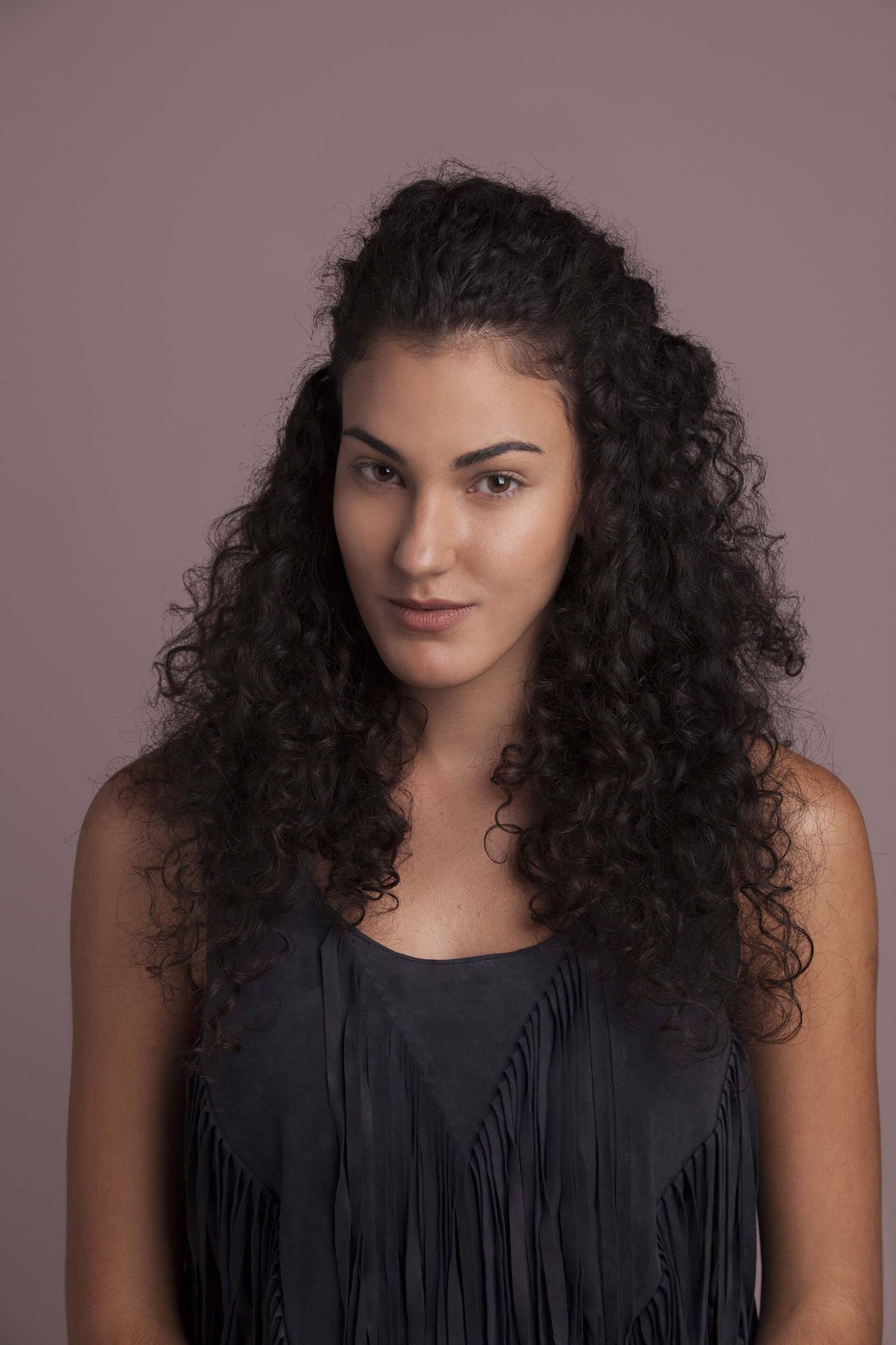 Modelo com cabelo cacheado castanho com duplo afro puff