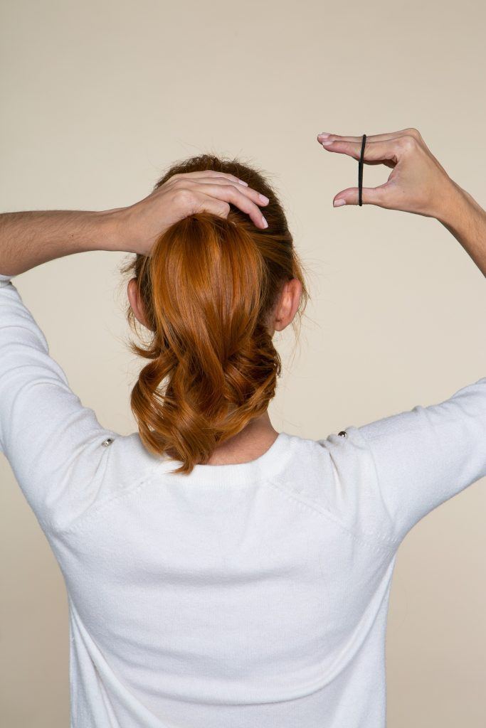 Modelo prendendo o cabelo em um rabo de cavalo