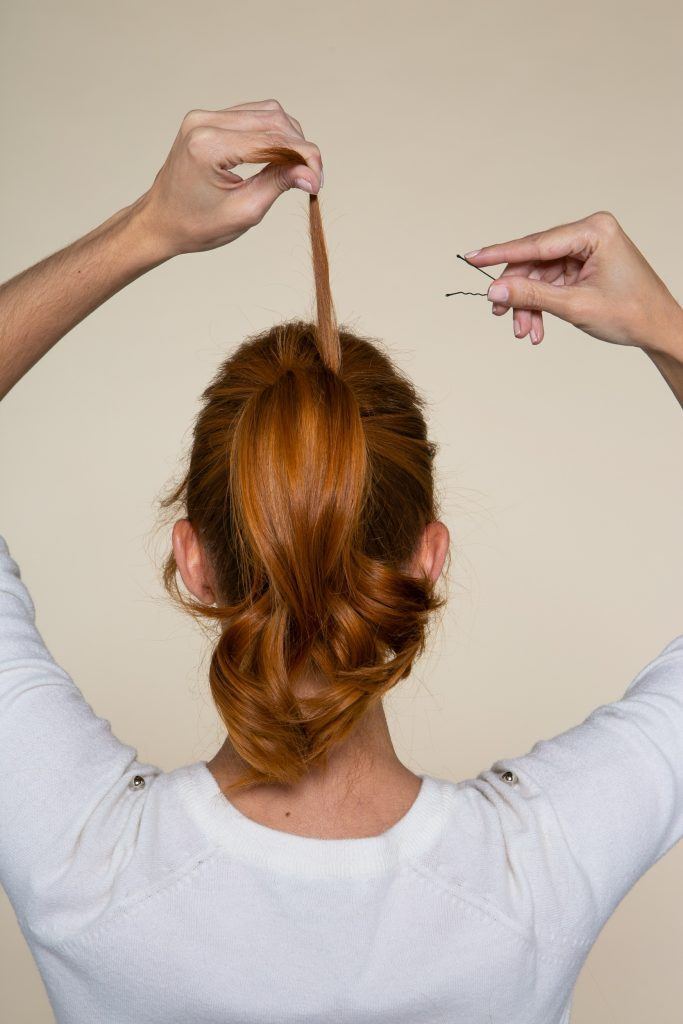 Modelo colocando grampo no cabelo
