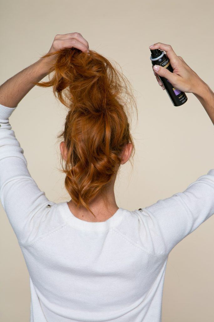 Modelo aplicando shampoo seco no rabo de cavalo