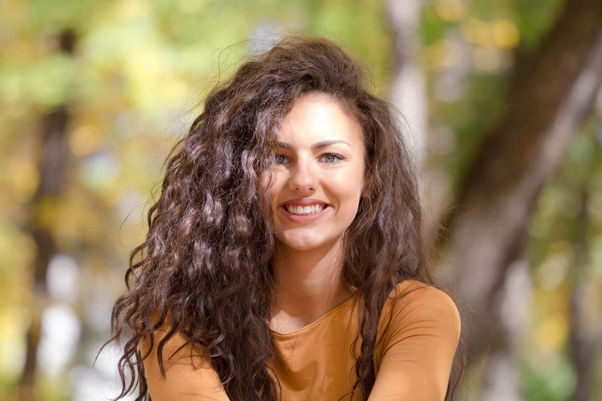 modelo com cabelo cacheado sorrindo: secar cabelo cacheado com ventilador