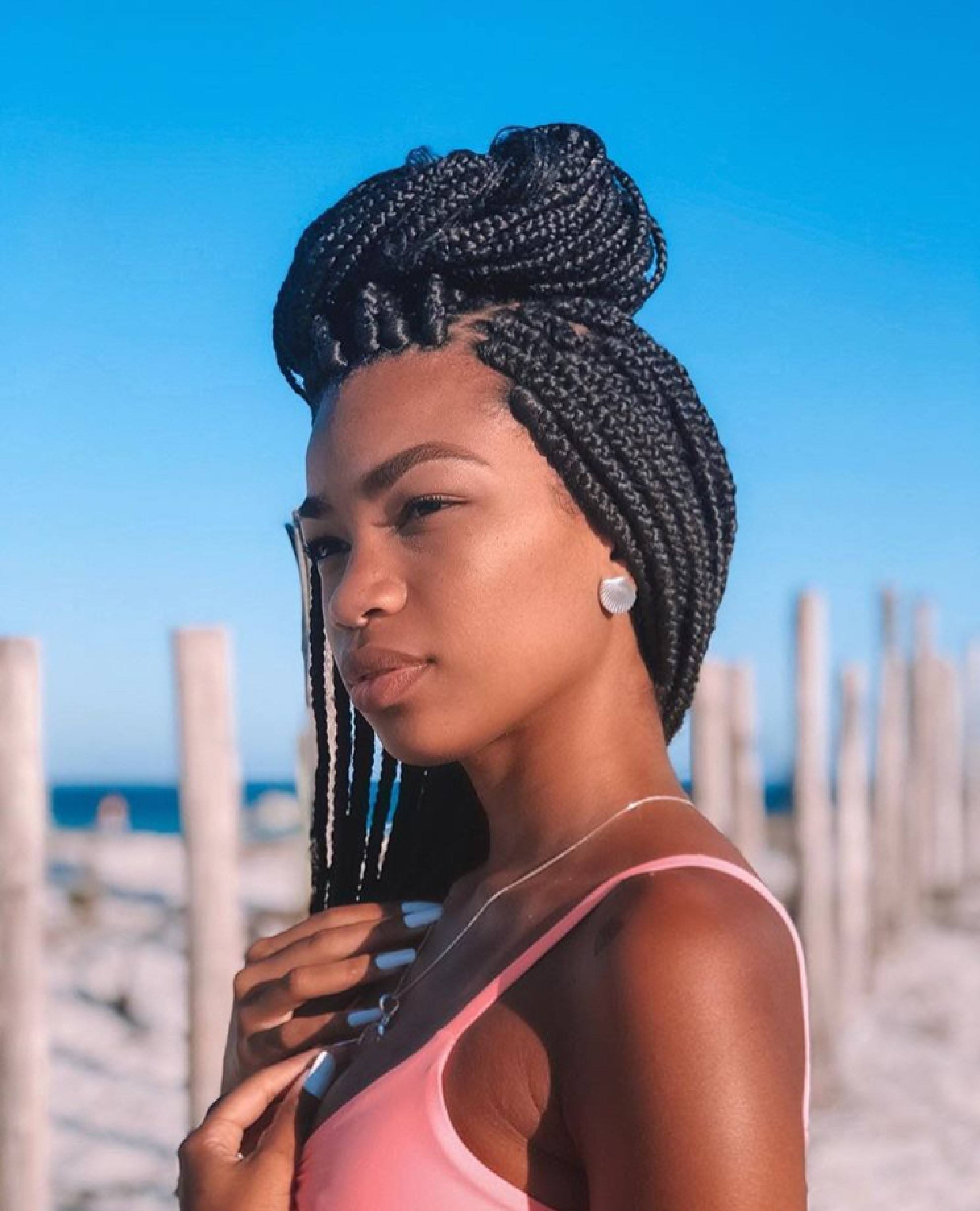 Modelo com tranças jumbo em penteado semipreso e regata rosa