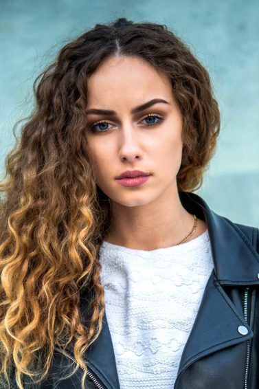 modelo com cabelos cacheados com mechas californianas