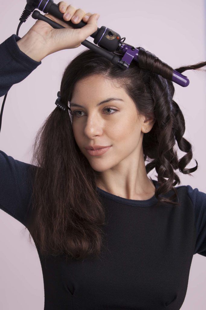 Mulher com cabelos pretos usando babyliss