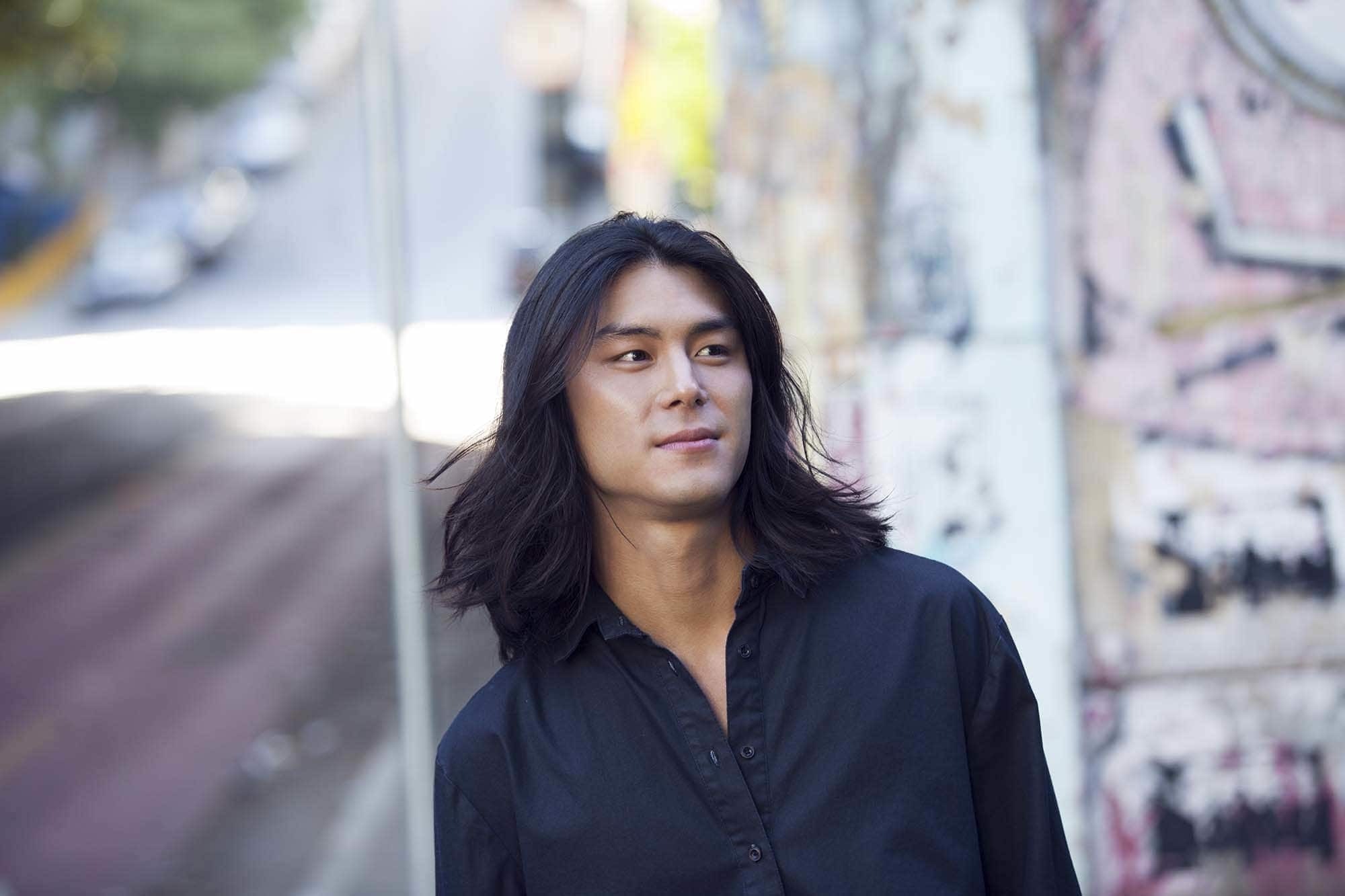 Modelo oriental com cabelo longo preto para matéria de cronograma capilar para homem