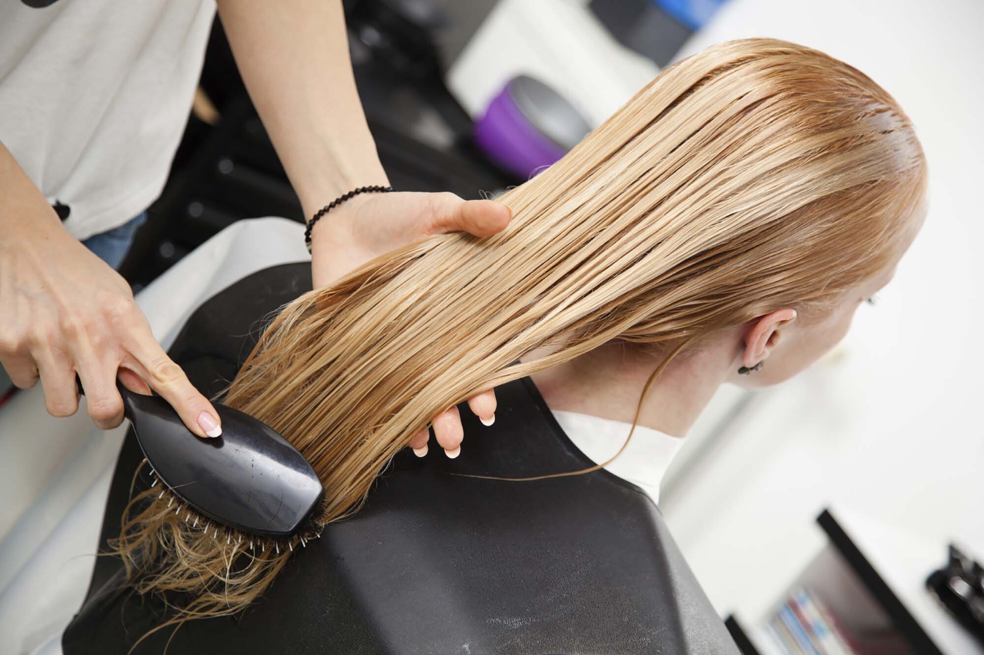 Mulher loira se submete a tratamentos de cabelo no salão