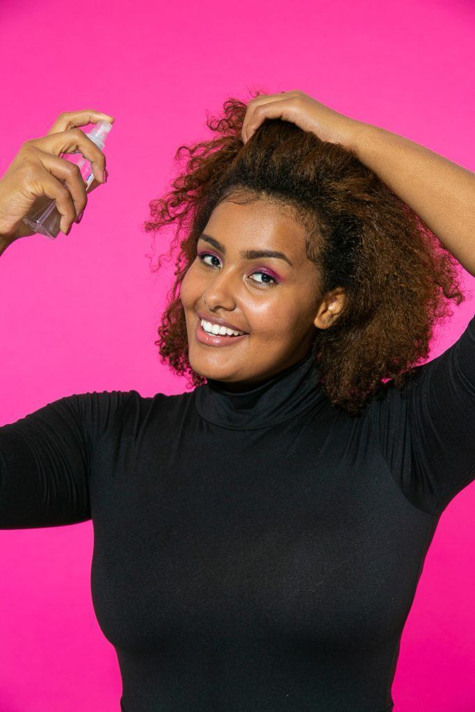 Cabelo cacheado sendo molhado para fazer afro puff