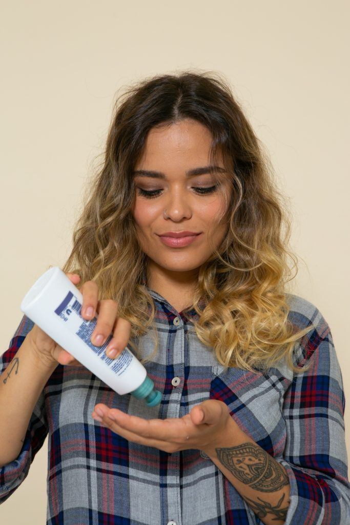 passando creme para pentear no cabelo