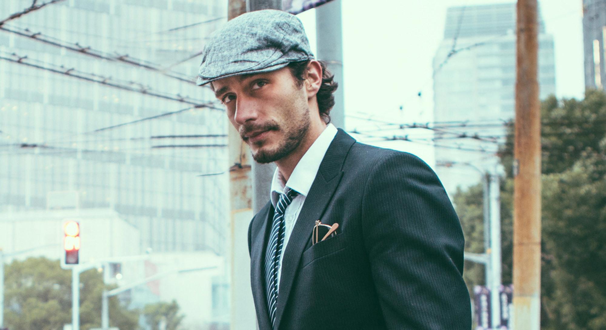 Homem com barba e cabelos castanho-claro e boina