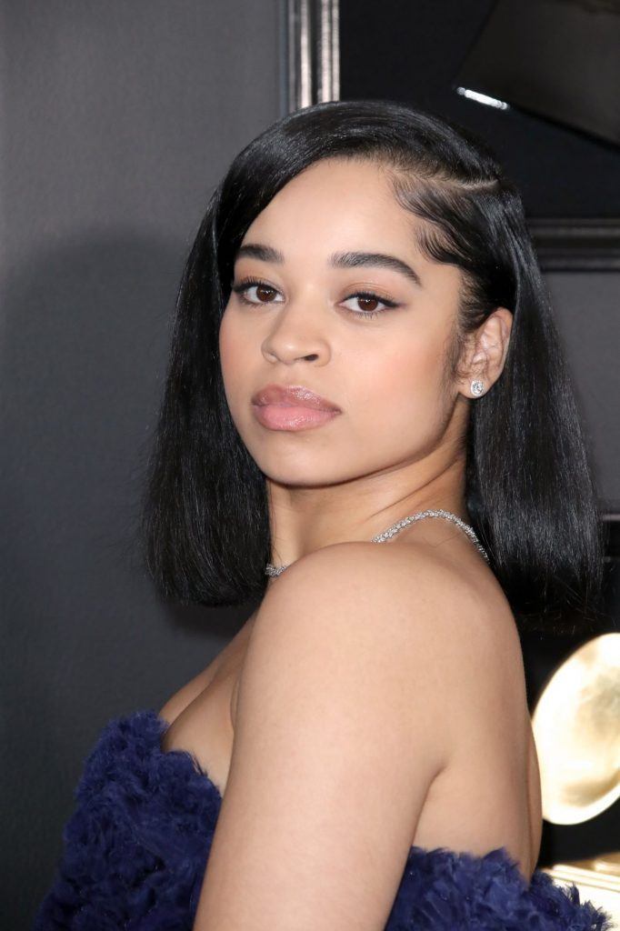 Ella Mai com cabelos soltos e baby hair modelado