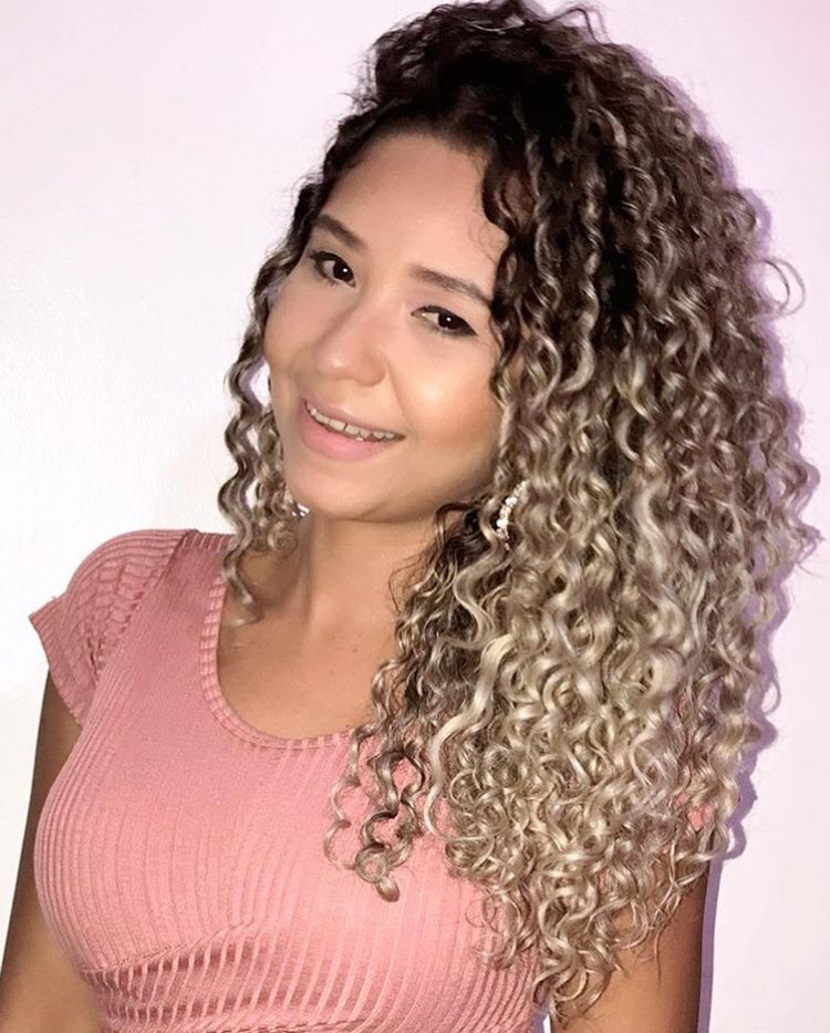 Mulher com cabelo platinado cacheado ombré