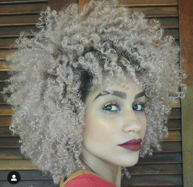 Mulher com cabelo platinado cacheado curto