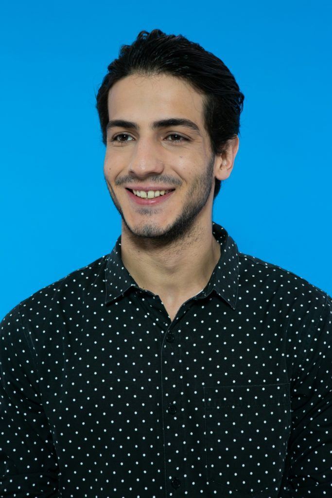 modelo masculino em fundo azul de cabelo preto curto